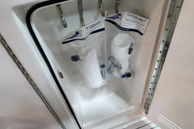Slide: The Image of Storage compartment with coiled hoses in a 2026 Formula 400 Super Sport Crossover boat. - 58