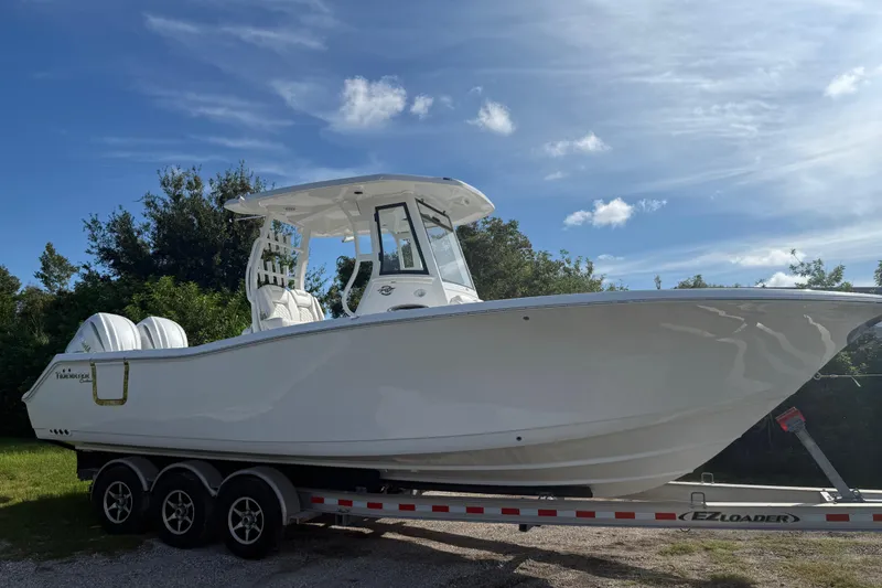 Slide: The Image of 2026 Tidewater 282 CC Adventure boat on trailer under blue sky. - 15