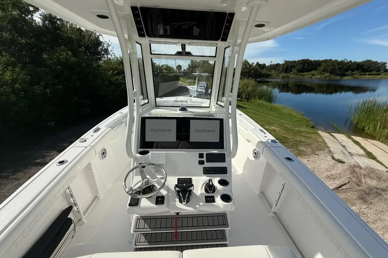 Slide: The Image of 2026 Tidewater 282 CC Adventure boat with Garmin navigation, docked by a serene lake. - 20