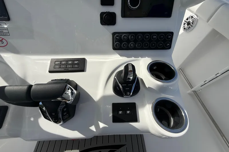 Slide: The Image of Control panel of 2026 Tidewater 282 CC Adventure boat with cup holders and switches. - 22