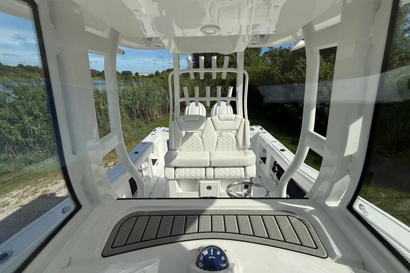 Slide: The Image of 2026 Tidewater 282 CC Adventure boat interior with white seating and steering wheel. - 28