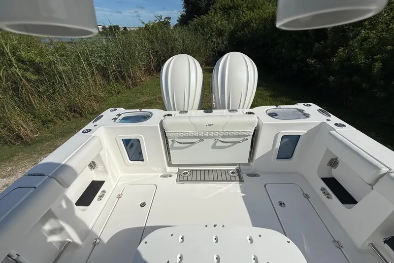 Slide: The Image of 2026 Tidewater 282 CC Adventure boat deck with dual engines, surrounded by lush greenery. - 30