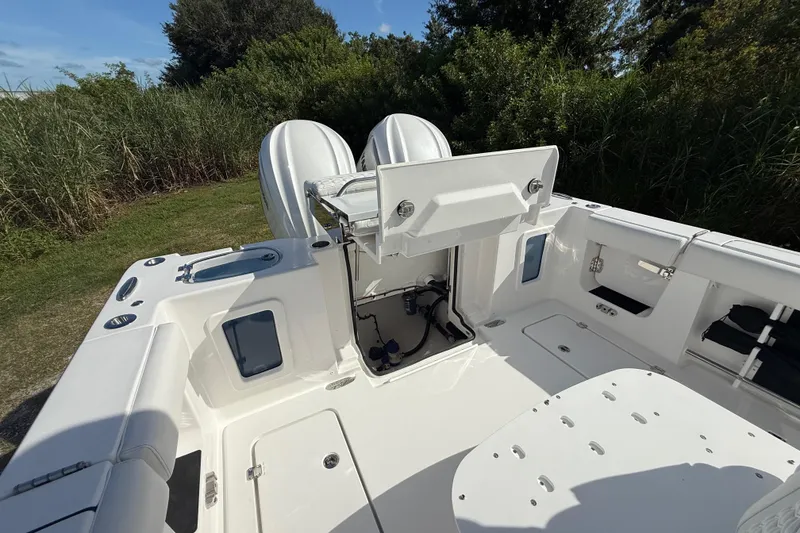Slide: The Image of 2026 Tidewater 282 CC Adventure boat interior with open storage compartments and dual engines. - 32