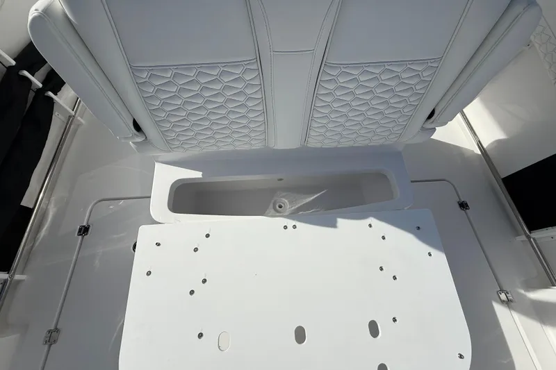 Slide: The Image of 2026 Tidewater 282 CC Adventure boat interior with white seating and storage compartment. - 38