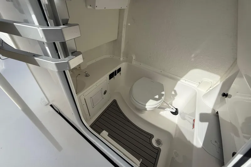Slide: The Image of 2026 Tidewater 282 CC Adventure boat interior with compact marine toilet and sink. - 49