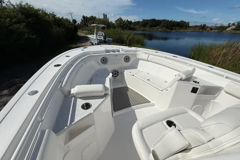 Slide: The Image of 2026 Tidewater 282 CC Adventure boat interior with seating and cup holders by a serene lake. - 51