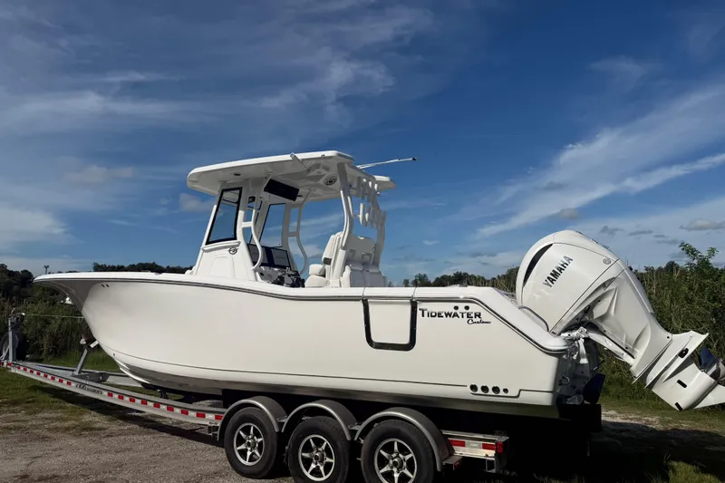 Slide: The Image of 2026 Tidewater 282 CC Adventure boat on trailer under clear blue sky. - 7