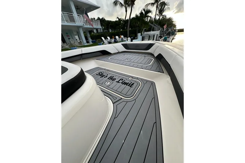 Slide: The Image of 2021 ShearWater 270 Carolina Flare boat deck with "Sky's the Limit" text, docked near palm trees. - 10