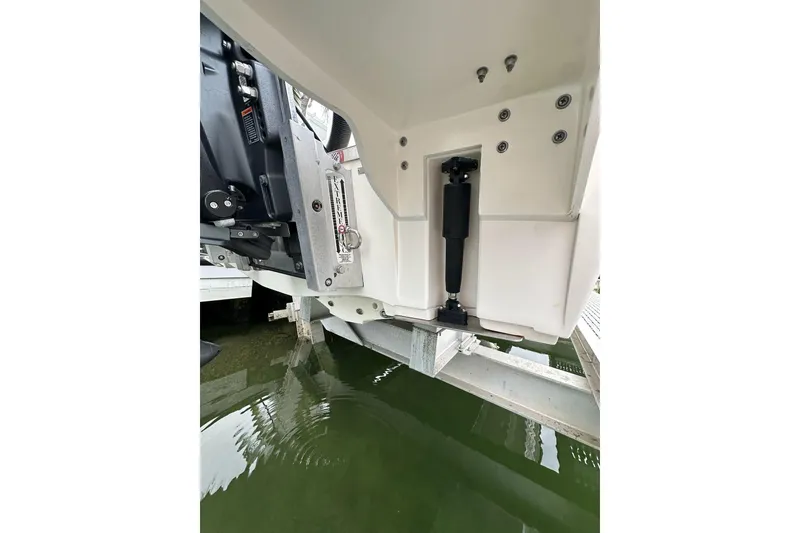 Slide: The Image of 2021 ShearWater 270 Carolina Flare boat engine detail on lift above water. - 32
