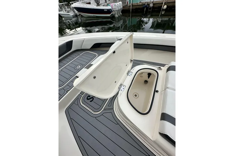 Slide: The Image of 2021 ShearWater 270 Carolina Flare boat with open storage compartment, docked by water. - 33