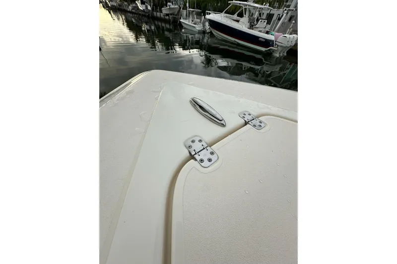 Slide: The Image of 2021 ShearWater 270 Carolina Flare boat deck with cleat and hinges, docked by water. - 47