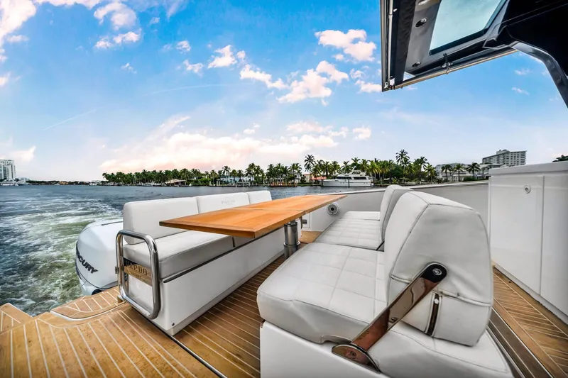 Slide: The Image of 2021 Pardo Yachts 38 with elegant seating and table, cruising on a scenic waterway. - 24