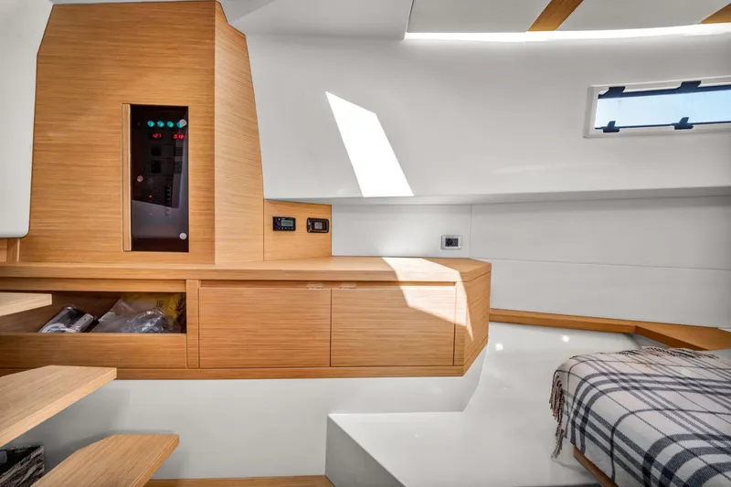 Slide: The Image of Interior of 2021 Pardo Yachts 38, featuring modern wood cabinetry and a cozy bed. - 39