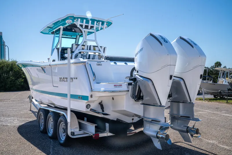 Slide: The Image of 2023 Blackfin 302 CC boat with dual Mercury engines on a trailer. - 10