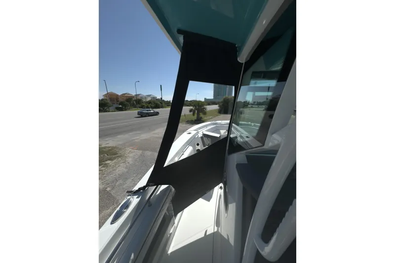 Slide: The Image of 2023 Blackfin 302 CC boat with sleek design, parked near a road. - 14