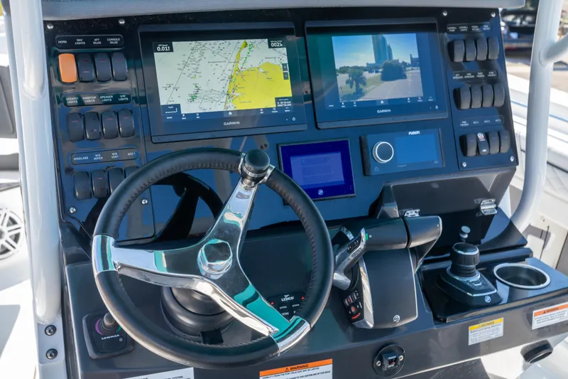 Slide: The Image of 2023 Blackfin 302 CC boat dashboard with steering wheel and navigation screens. - 16