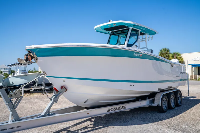 Slide: The Image of 2023 Blackfin 302 CC boat on trailer, displayed outdoors under clear blue sky. - 2