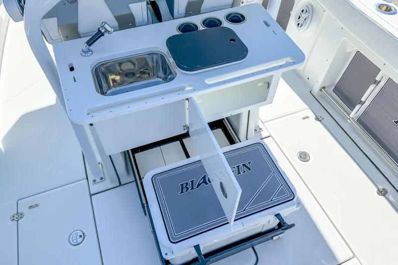 Slide: The Image of 2023 Blackfin 302 CC boat interior with sink, storage, and cooler. - 24