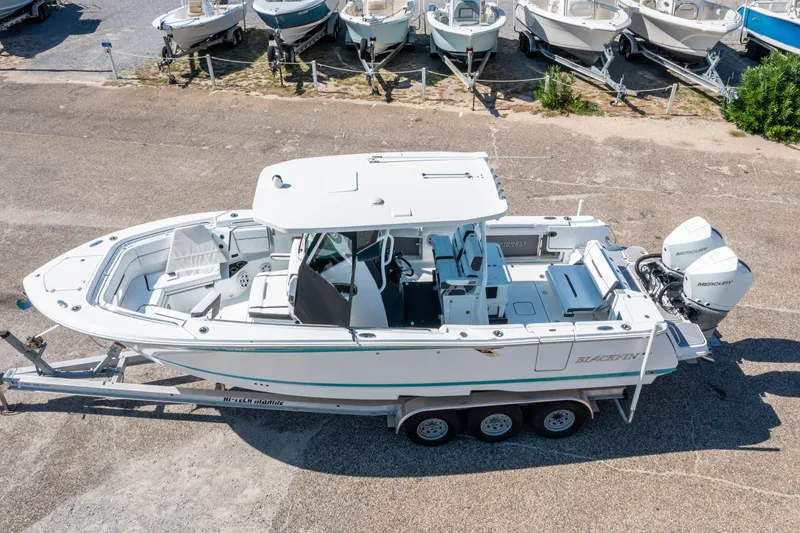 Slide: The Image of 2023 Blackfin 302 CC boat on trailer, aerial view, parked with other boats. - 3