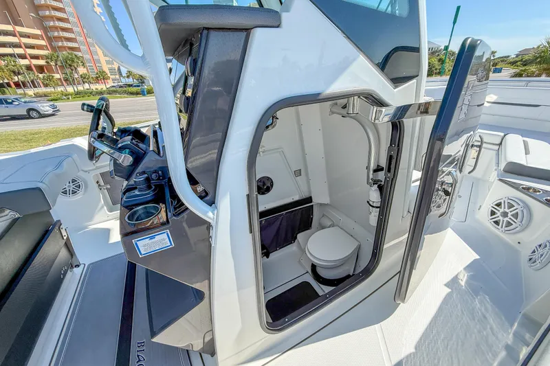 Slide: The Image of 2023 Blackfin 302 CC boat interior with helm and compact restroom. - 31
