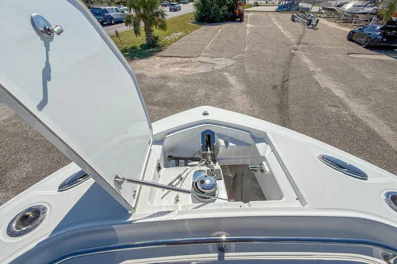 Slide: The Image of 2023 Blackfin 302 CC boat anchor compartment, open lid, docked on a sunny day. - 38