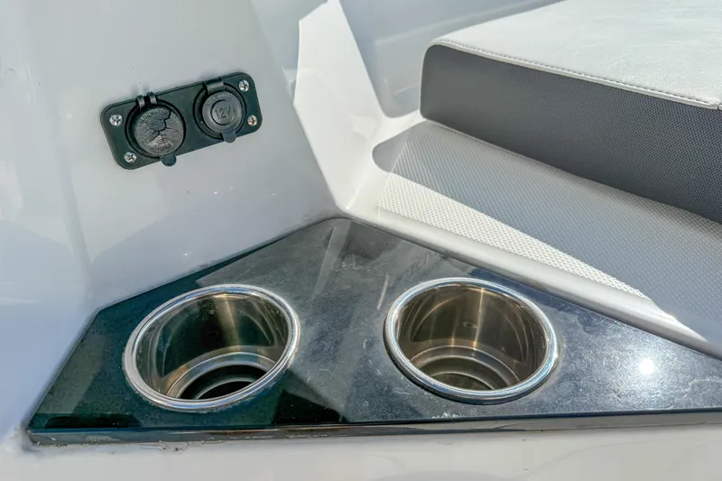 Slide: The Image of 2023 Blackfin 302 CC boat interior with dual cup holders and 12V power outlets. - 45