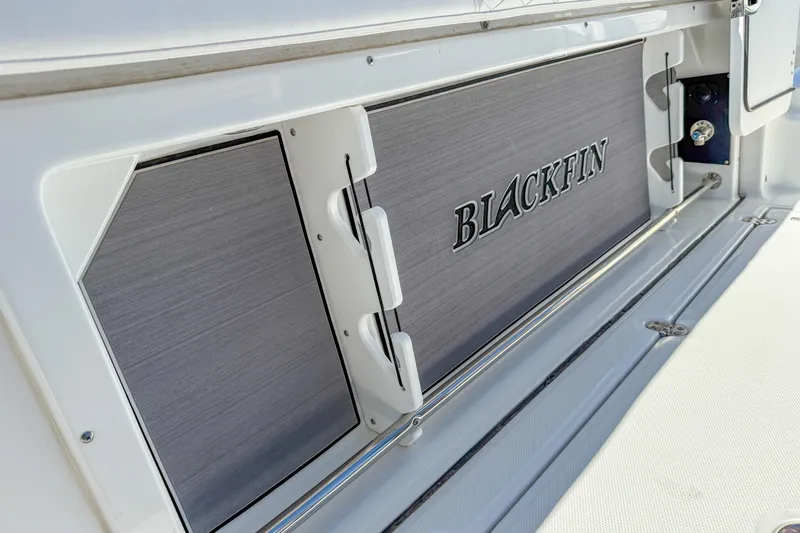 Slide: The Image of 2023 Blackfin 302 CC boat interior detail with logo and storage compartment. - 48