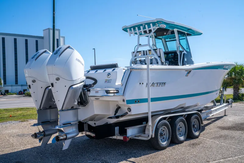 Slide: The Image of 2023 Blackfin 302 CC boat on trailer with dual Mercury engines, parked outdoors. - 8