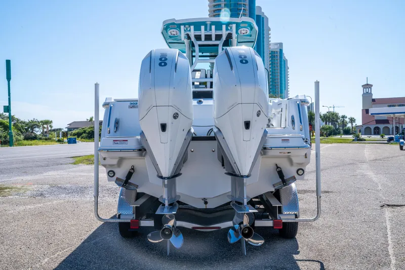 Slide: The Image of 2023 Blackfin 302 CC boat with dual outboard engines, parked on a sunny day. - 9