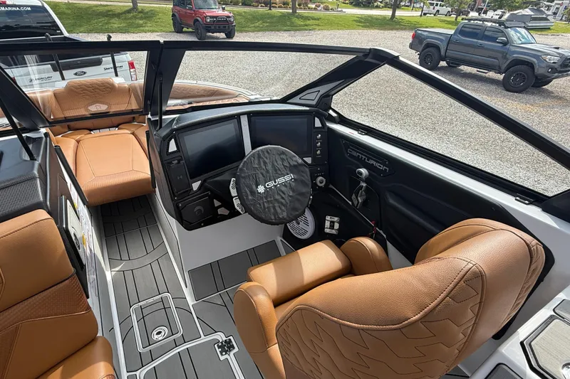 Slide: The Image of 2026 Centurion Ri245 boat interior with tan seats and modern dashboard design. - 12
