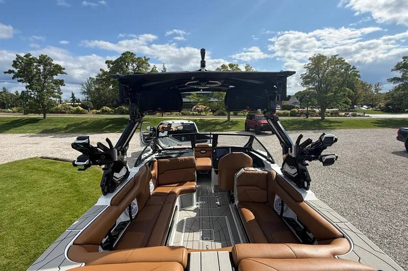 Slide: The Image of 2026 Centurion Ri245 boat with luxurious brown seating and advanced features, parked outdoors. - 17