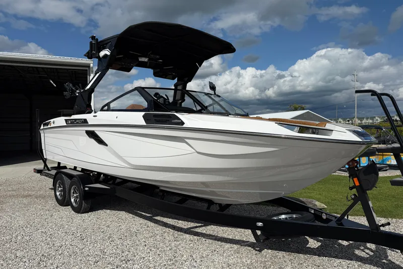 Slide: The Image of 2026 Centurion Ri245 boat on trailer, parked outdoors under cloudy sky. - 3