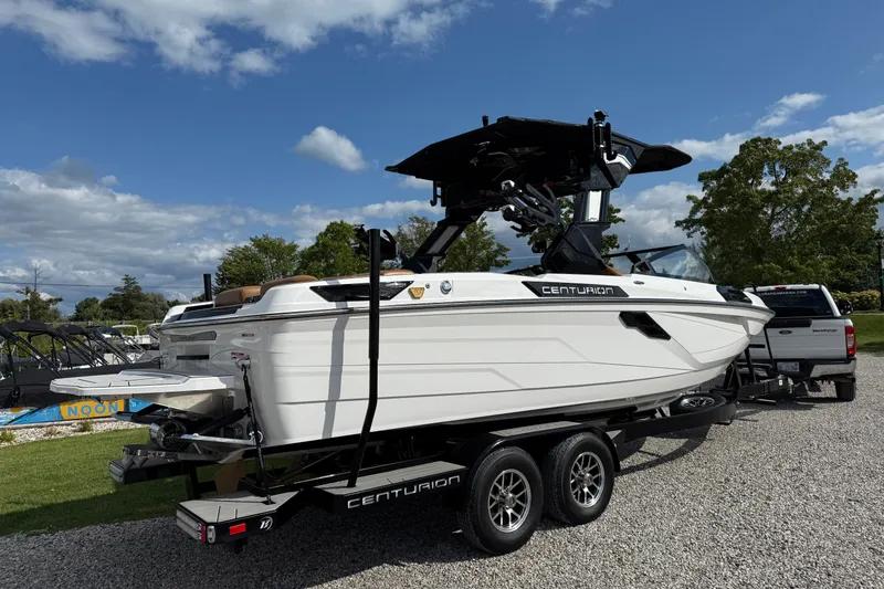 Slide: The Image of 2026 Centurion Ri245 boat on trailer, parked outdoors under a partly cloudy sky. - 4