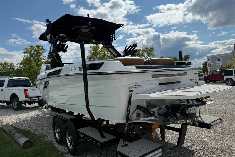 Slide: The Image of 2026 Centurion Ri245 boat on trailer, parked outdoors under a partly cloudy sky. - 8