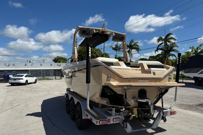 Slide: The Image of 2026 Nautique Super Air Nautique S23 boat on trailer under clear blue sky. - 10