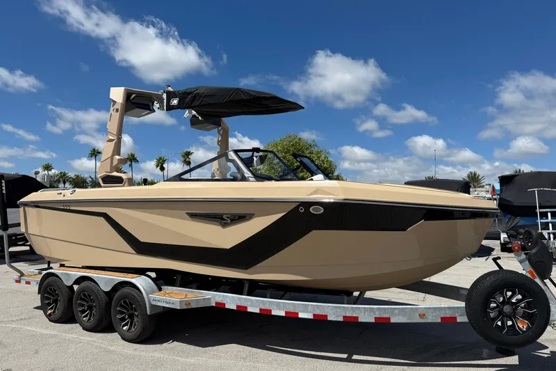 Slide: The Image of 2026 Nautique Super Air Nautique S23 boat on trailer under blue sky. - 2