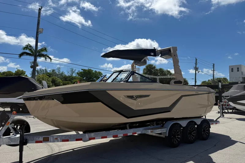 Slide: The Image of 2026 Nautique Super Air Nautique S23 boat on trailer under blue sky. - 3