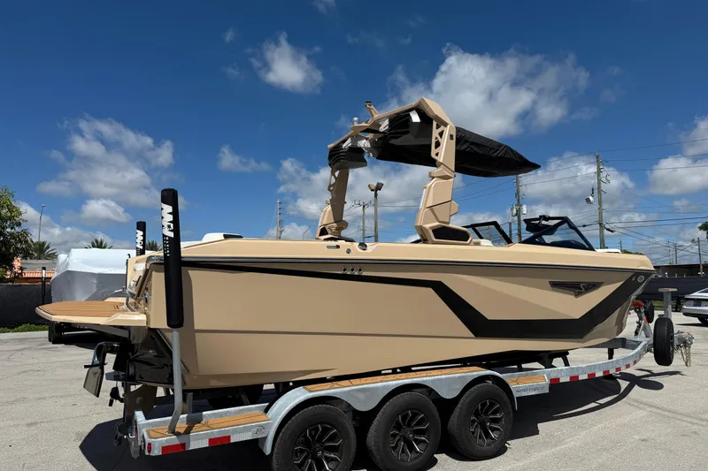 Slide: The Image of 2026 Nautique Super Air Nautique S23 boat on trailer under blue sky. - 4