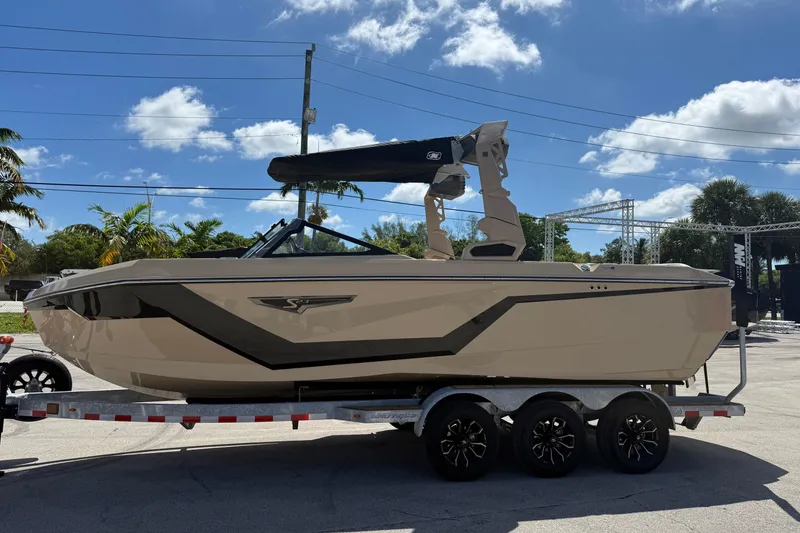 Slide: The Image of 2026 Nautique Super Air Nautique S23 boat on trailer under clear blue sky. - 6