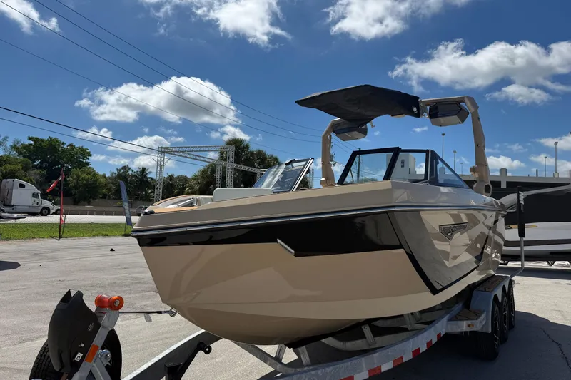 Slide: The Image of 2026 Nautique Super Air Nautique S23 boat on trailer under blue sky. - 7