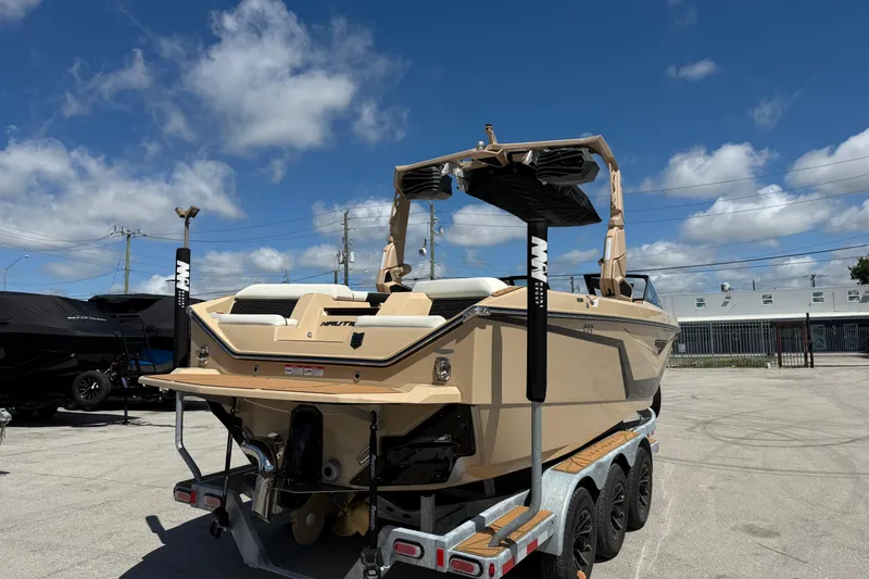 Slide: The Image of 2026 Nautique Super Air Nautique S23 boat on trailer under clear blue sky. - 9