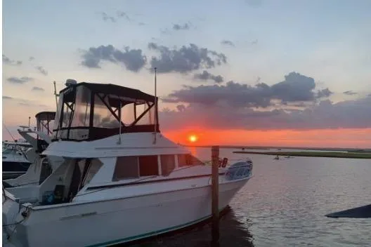 The Image of 1992 Mainship 35 Convertible yacht docked at sunset with scenic sky. - 0