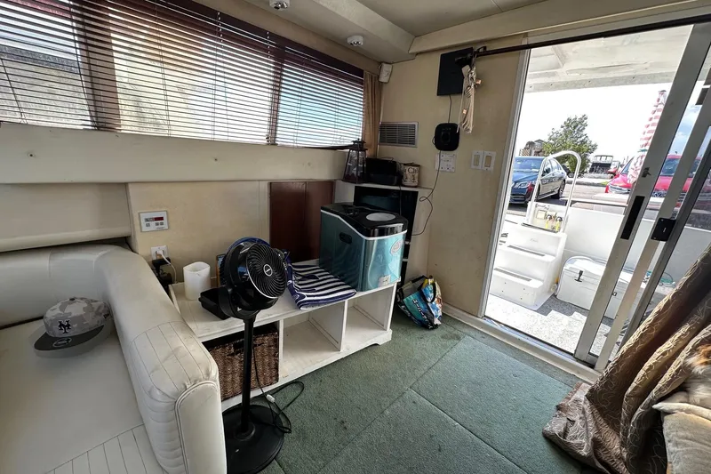 Slide: The Image of Interior of 1992 Mainship 35 Convertible yacht with seating, fan, and open sliding door. - 12