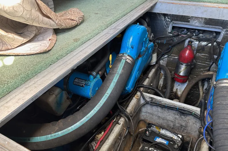 Slide: The Image of 1992 Mainship 35 Convertible engine compartment with blue components and fire extinguisher. - 14