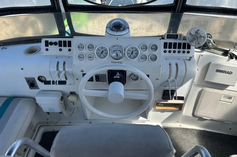 Slide: The Image of 1992 Mainship 35 Convertible helm with gauges, steering wheel, and navigation equipment. - 3
