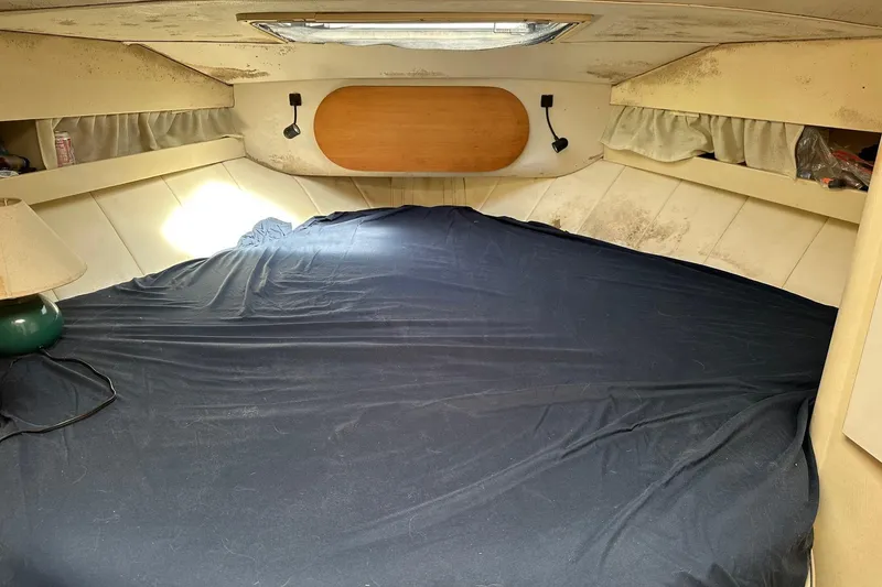 Slide: The Image of 1992 Mainship 35 Convertible cabin interior with bed, lamp, and storage shelves. - 7