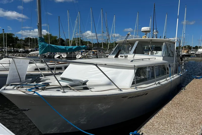 The Image of 1967 Chris-Craft 31 Commander docked at a marina under a clear blue sky. - 0