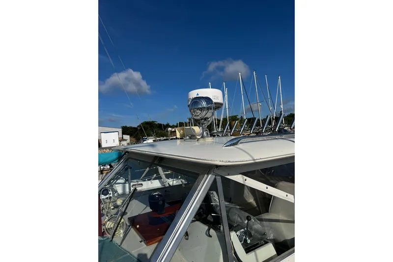 Slide: The Image of 1967 Chris-Craft 31 Commander boat with radar and spotlight, under clear blue sky. - 16
