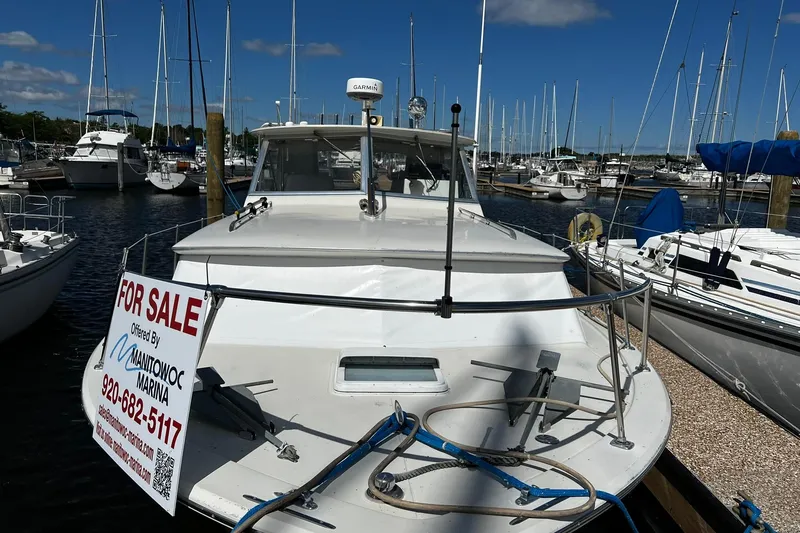 Slide: The Image of 1967 Chris-Craft 31 Commander boat for sale at marina, surrounded by other vessels. - 2