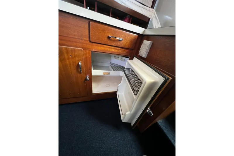 Slide: The Image of 1967 Chris-Craft 31 Commander interior with open fridge and wooden cabinetry. - 20